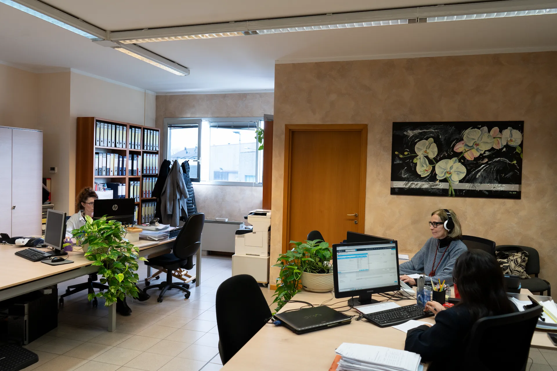 Ufficio con scrivania, sedia e scaffali, illuminato da una finestra