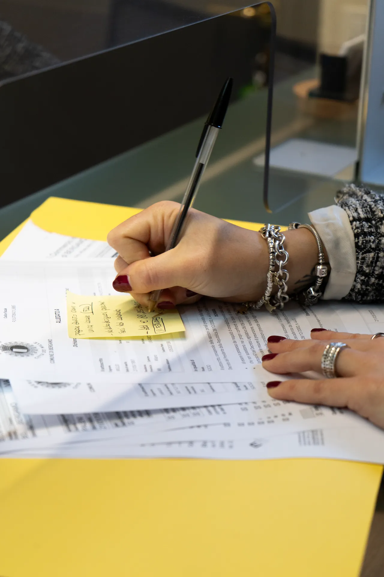 Una donna scrive su un foglio di carta con una penna