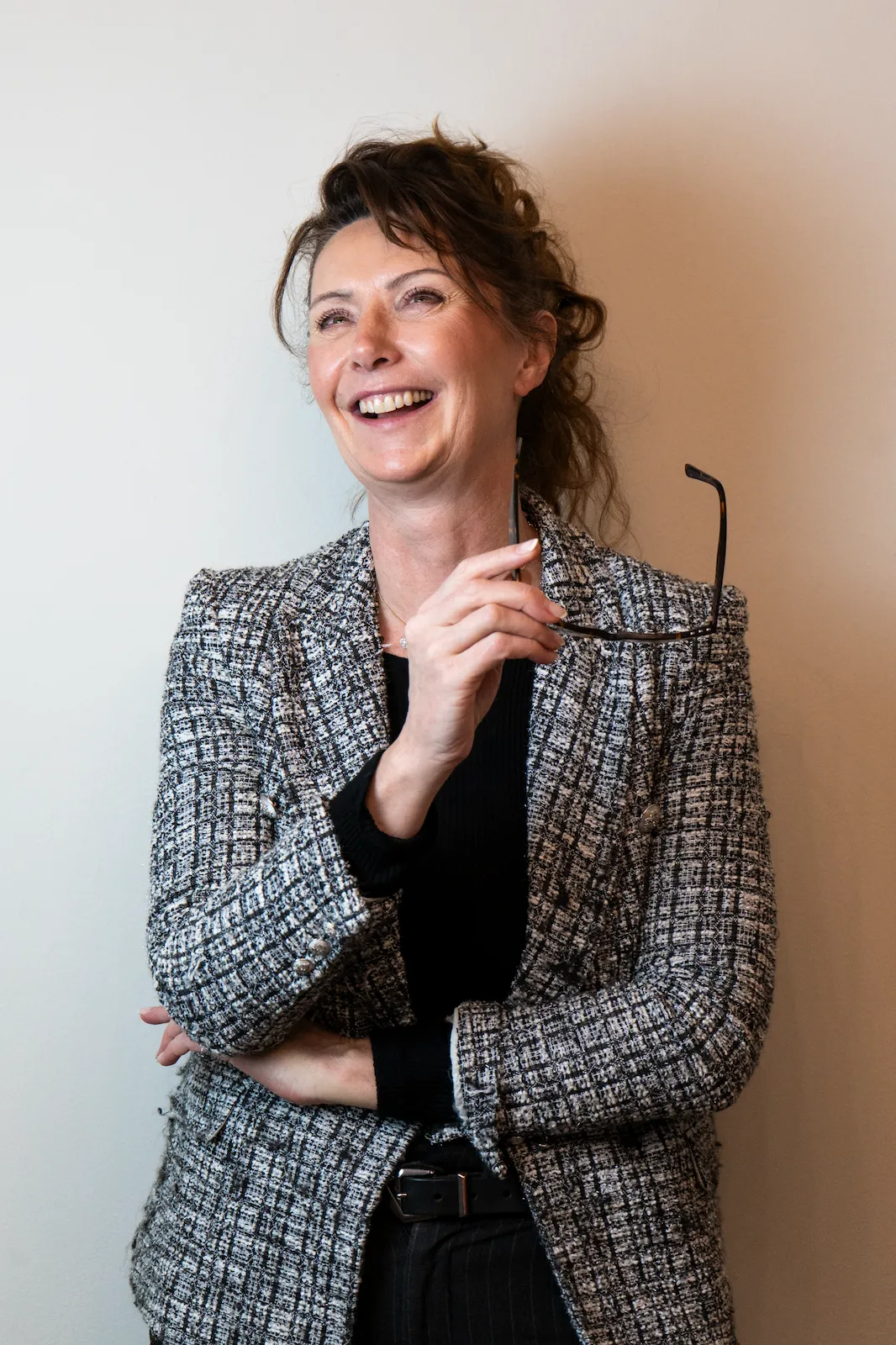 Donna sorridente che tiene un paio di occhiali tra le mani